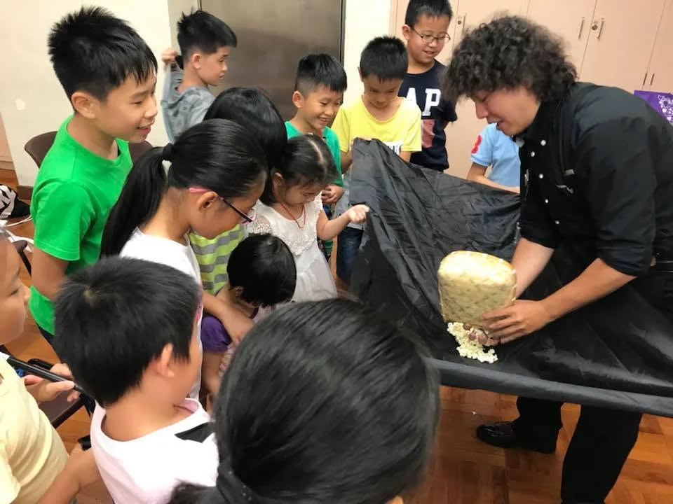 導師向圍觀的小朋友示範魔術。